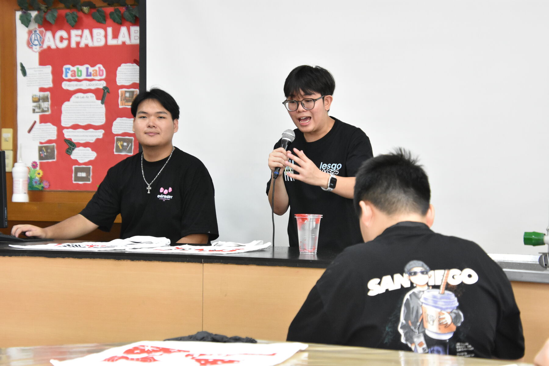 A LESGO team member talks to the room, microphone in hand